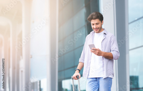 Ordering Taxi. Man Using Smartphone While Standing With Suitcase Near Airport Free Download Ordering Taxi. Man Using Smartphone While Standing With Suitcase Near Airport - GFXLoad