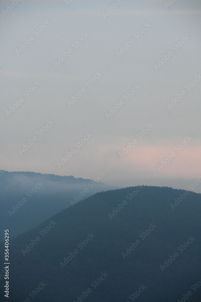 Sommet des montagnes à l'aube dans le brouillard et la pénombre