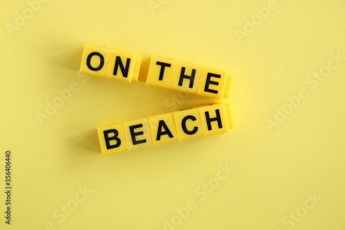 on the beach - inscription in yellow letters on a yellow background