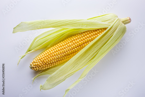 fresh corn cob on white acrylic background