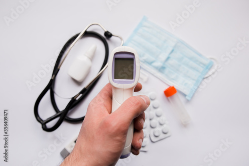 electronic thermometer in a hand pills and mask