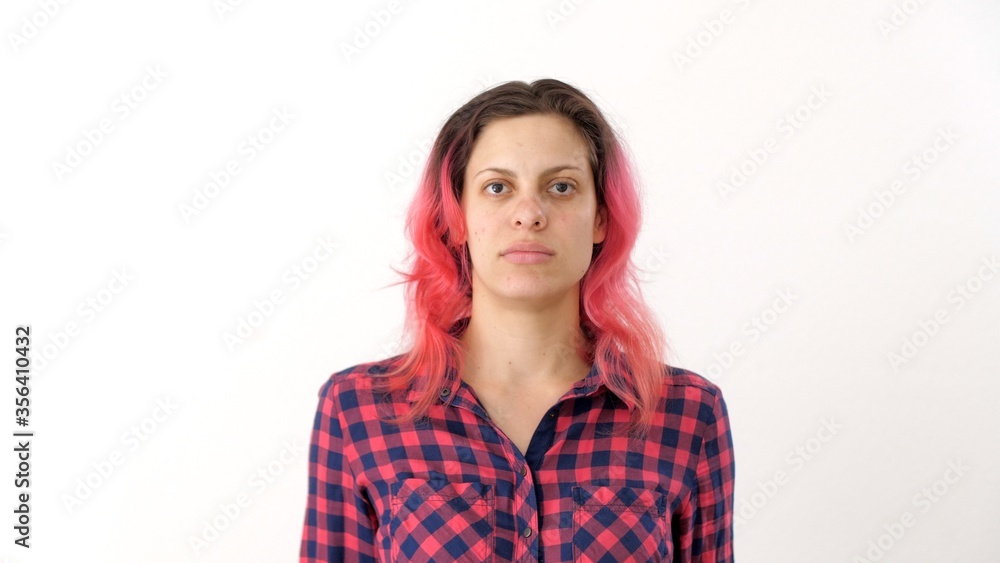 Portrait of young woman with pink hair in a plaid shirt. Sweet adult girl poses for photographer for passport photo. Portrait of young woman with pink hair in a plaid shirt. Sweet adult girl poses for photographer for passport photo.