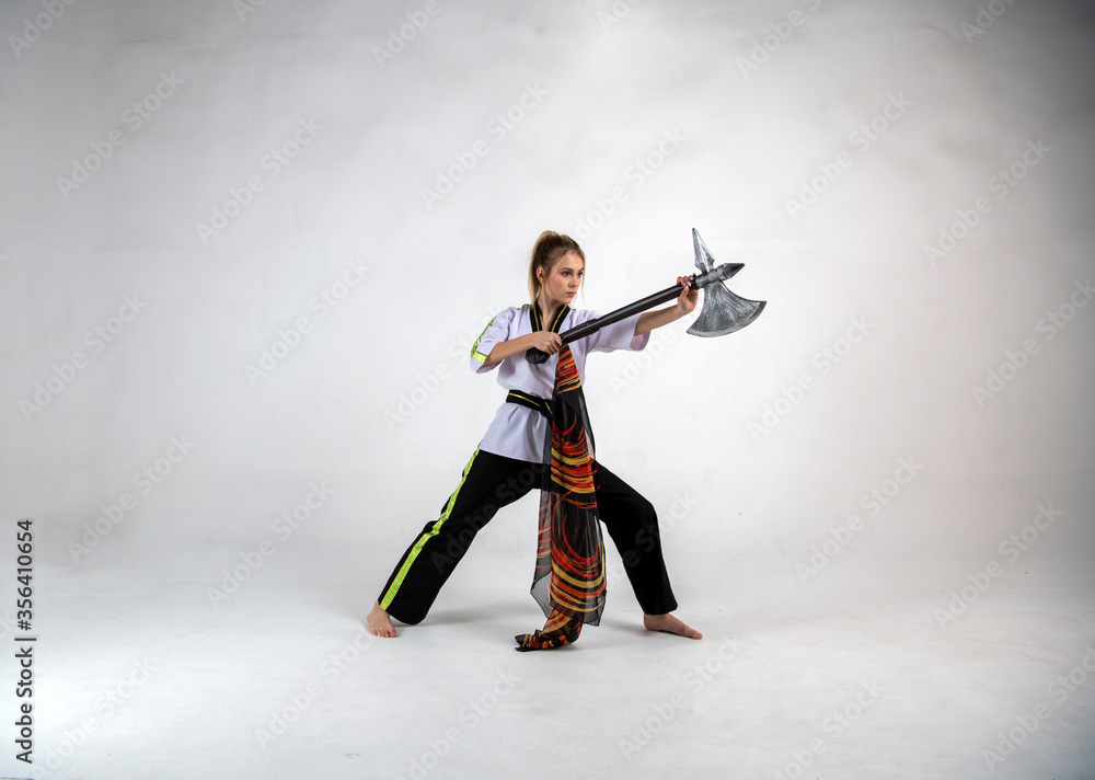 beautiful girl in a white-black suit does exercises with a battle ax and a scarf beautiful girl in a white-black suit does exercises with a battle ax and a scarf