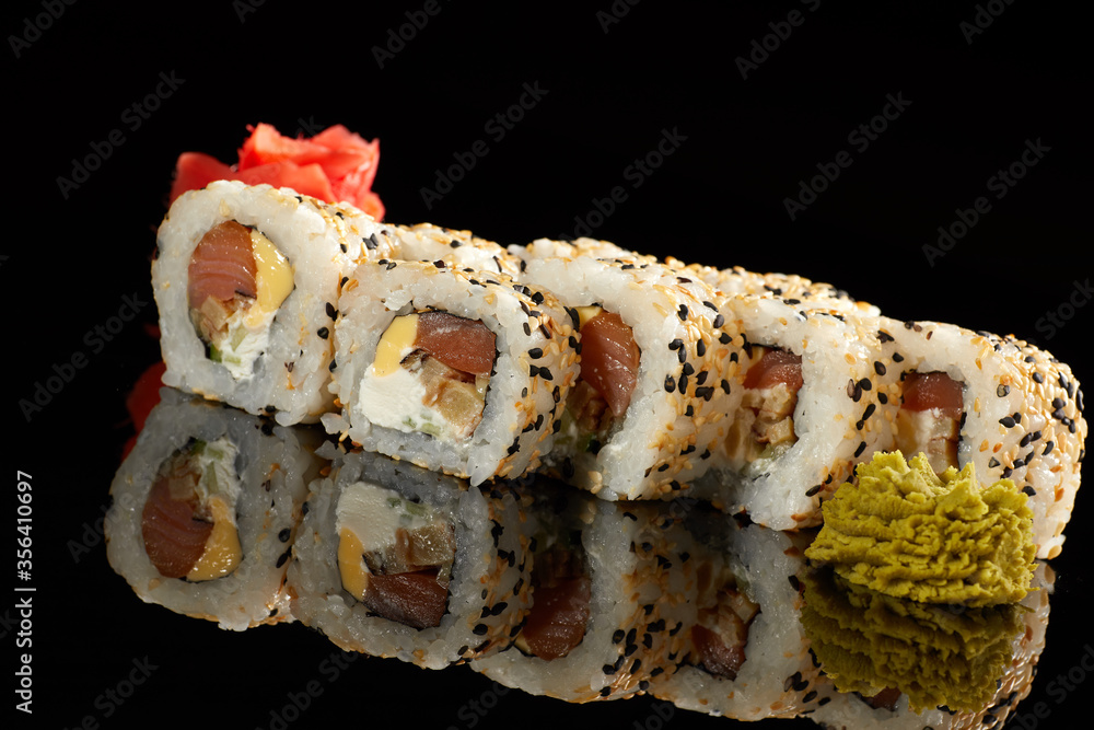 Japanese Cuisine - Appetizing Salmon Sushi Set. Philadelphia Sushi Roll - Maki Sushi with Philadelphia Cheese inside on mirror black background. Smoked salmon rolls served on a plate Japanese Cuisine - Appetizing Salmon Sushi Set. Philadelphia Sushi Roll - Maki Sushi with Philadelphia Cheese inside on mirror black background. Smoked salmon rolls served on a plate