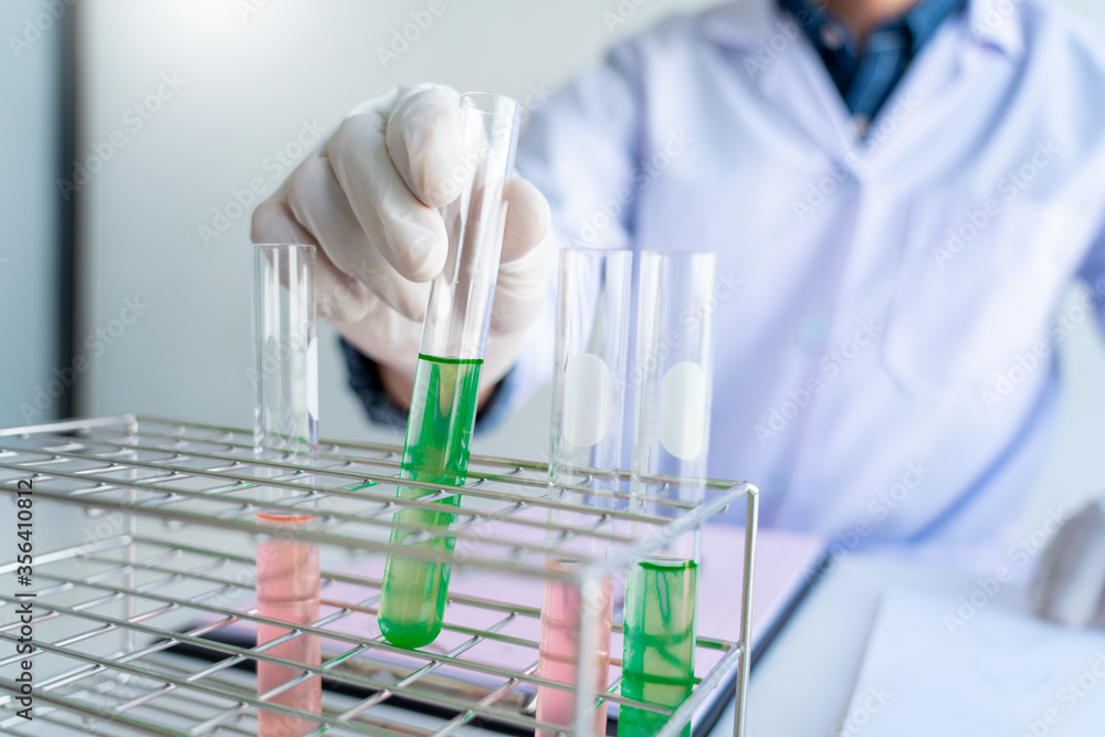 Scientist wear lab coat and protective wear are working with research or doing investigations with test tubes in experiment, Laboratory and development concept Scientist wear lab coat and protective wear are working with research or doing investigations with test tubes in experiment, Laboratory and development concept