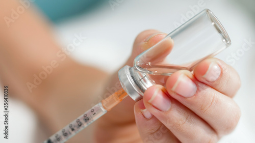 Macro image of syringe needle in glass bottle with medicines