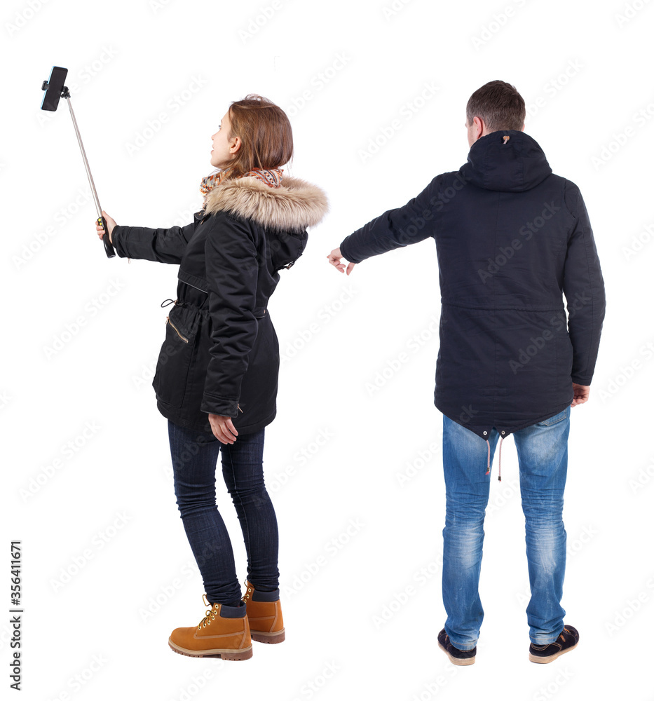 Back view of couple in winter jacket photographed on a mobile phone in winter jacket. Back view of couple in winter jacket photographed on a mobile phone in winter jacket.