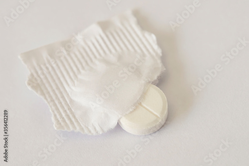 The tablet is white round. Macro photo. The medicine close-up. The cylindrical shape of the tablet. Old-style drug.