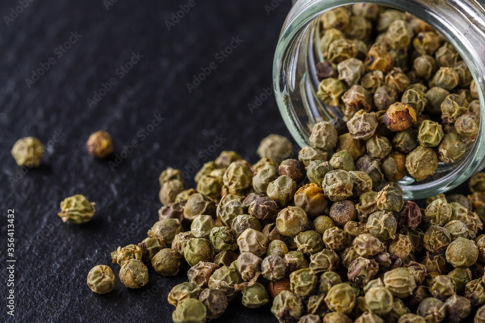 green peppercorns on dark slate stone background green peppercorns on dark slate stone background