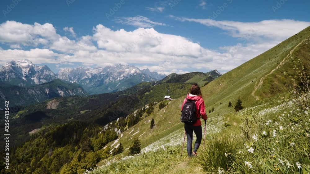 Caucasian female hiker walking on top of the mountain with amazing view