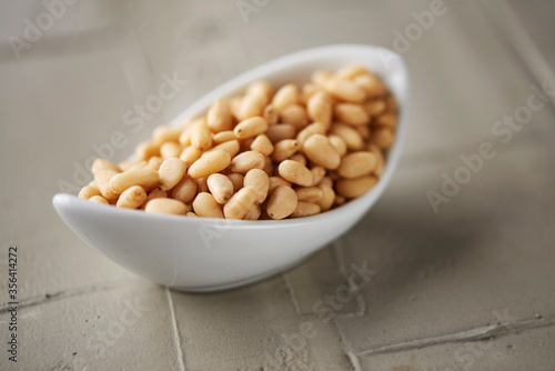 shelled pine nuts in a white bowl