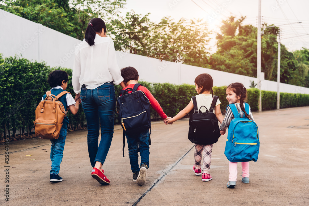 Back family parent happy children kid boy son kindergarten holding hand carry school backpack walking sidewalk to school. Young mom smile have funny, Back to school first day of semester concept
