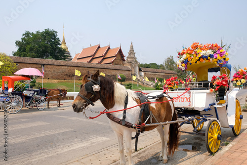 Horse carriage stand in front of Wat Phra That Lampang Luang, an ancient magnificent Lanna architecture in Lampang province, Thailand.