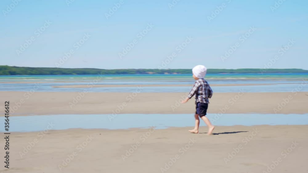 Cute little child running on the beach exploring life. Toddler enjoying sunny day on a vacation. Cute little child running on the beach exploring life. Toddler enjoying sunny day on a vacation.