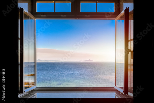 view from a dark room to the sea through an open window
