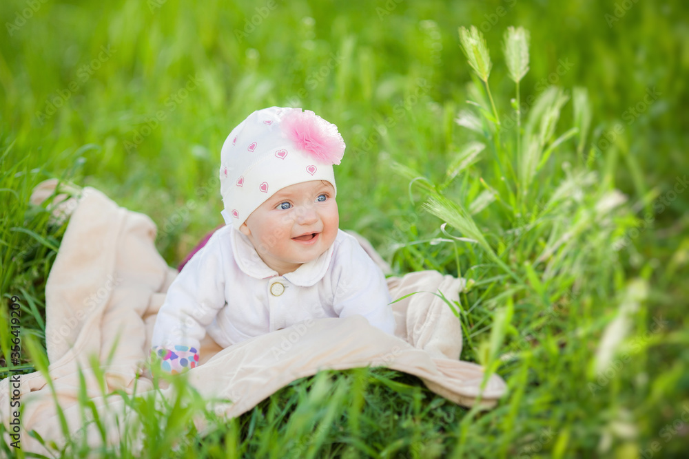 Beautiful happy baby girl sitting on green grass in the park. Beautiful happy baby girl sitting on green grass in the park.