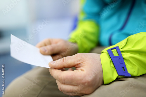 Man holding in hands sheet of paper with number in line