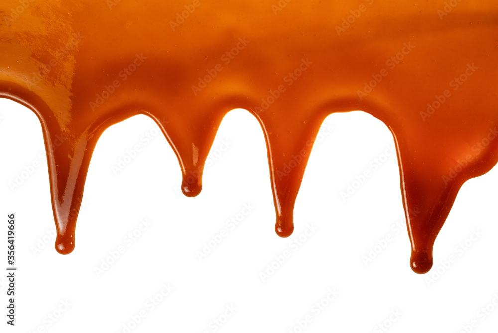 Background of flowing caramel sauce isolated on white.