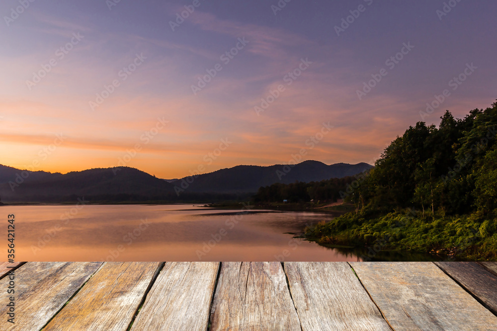 Wood table top on blurred beautiful sunset at the lake and mountain. Beauty natural background - can be used for product display montage