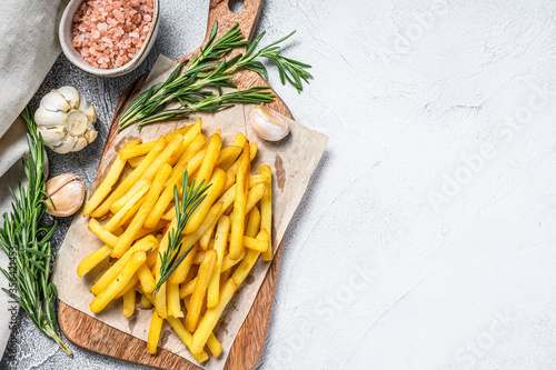 French fries on a cutting board, fried potatoes. White background. Top view. Copy space