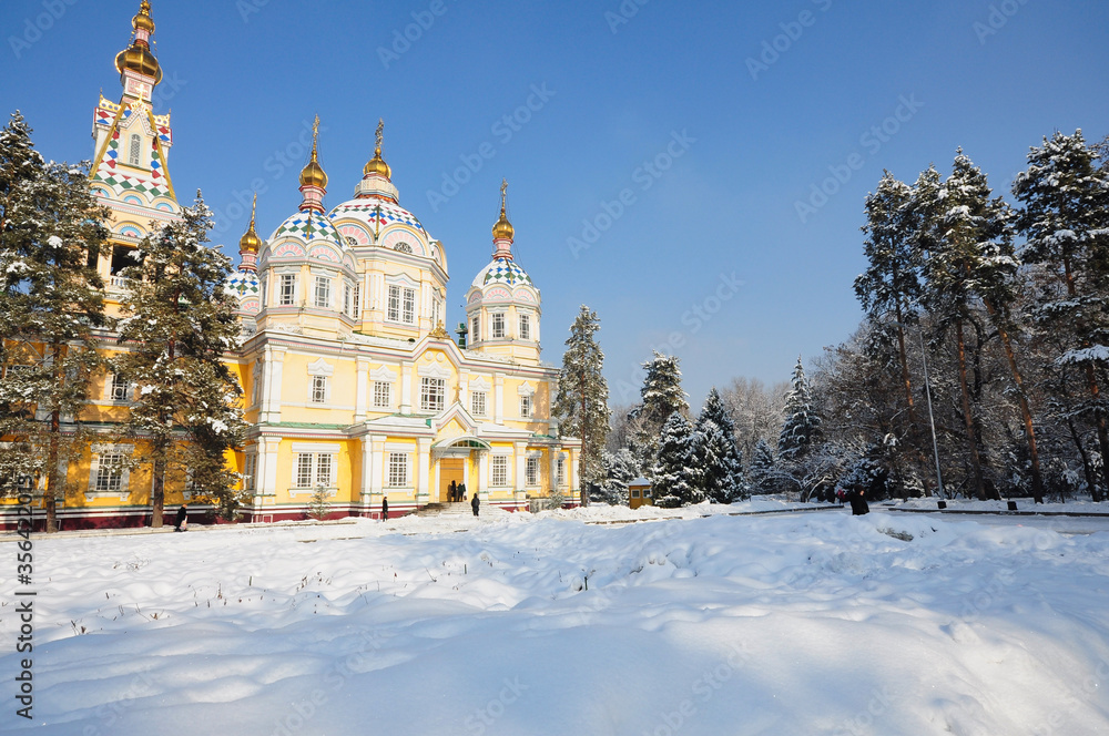 Brightly painted Ascension Cathedral in Almaty's Panfilov Park on a snowy winter's day under a clear blue sky. Brightly painted Ascension Cathedral in Almaty's Panfilov Park on a snowy winter's day under a clear blue sky.