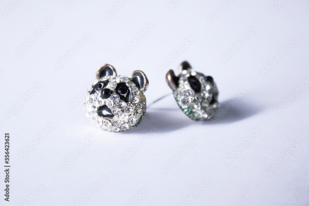 Silver earrings panda-shaped. jewelry and accessories concept. Isolated, copy space. Macro Shot. High quality photo Silver earrings panda-shaped. jewelry and accessories concept. Isolated, copy space. Macro Shot. High quality photo