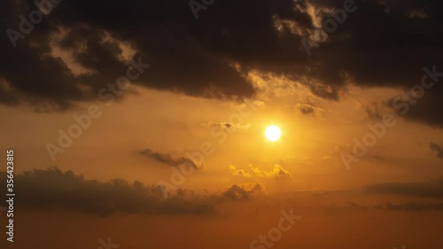 Dramatic sunset timelapse wirh sun going through the clouds