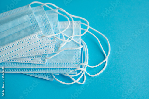 Medical protective masks on a blue background. Disposable 3-ply medical mask to cover the mouth and nose to prevent coronavirus. Coronavirus quarantine. Antivirus medical mask for protection covid-19.