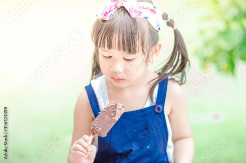 Close up background view Of ASEAN girls eating delicious ice cream  with chocolate flowing on clothes  the concept of self-learning