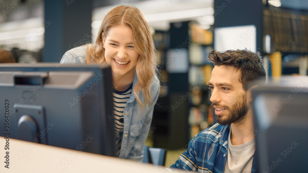 University Library: Bright Caucasian Girl and Talented Hispanic Boy Study for Exams As Team, Work on Assignment, Use Computer, Talk, Look for Solution, Explain Subject. College Students Work Together University Library: Bright Caucasian Girl and Talented Hispanic Boy Study for Exams As Team, Work on Assignment, Use Computer, Talk, Look for Solution, Explain Subject. College Students Work Together