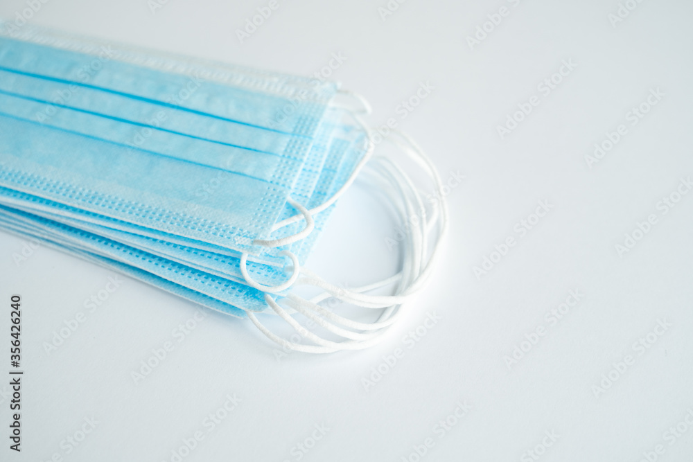 Medical protective masks on a gray background. Disposable 3-ply medical mask to cover the mouth and nose to prevent coronavirus. Coronavirus quarantine. Antivirus medical mask for protection covid-19. Medical protective masks on a gray background. Disposable 3-ply medical mask to cover the mouth and nose to prevent coronavirus. Coronavirus quarantine. Antivirus medical mask for protection covid-19.