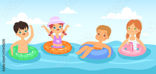 Multinational children have fun and jumping in the water. Boys and girls with inflatable rubber circles swimming in the sea. Happy kids having fun in the summer time. Landscape, panorama sea view