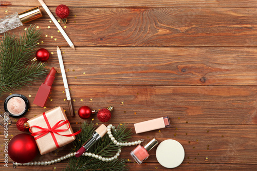 Beautiful composition with Christmas decor and makeup cosmetics on a colored background top view.
