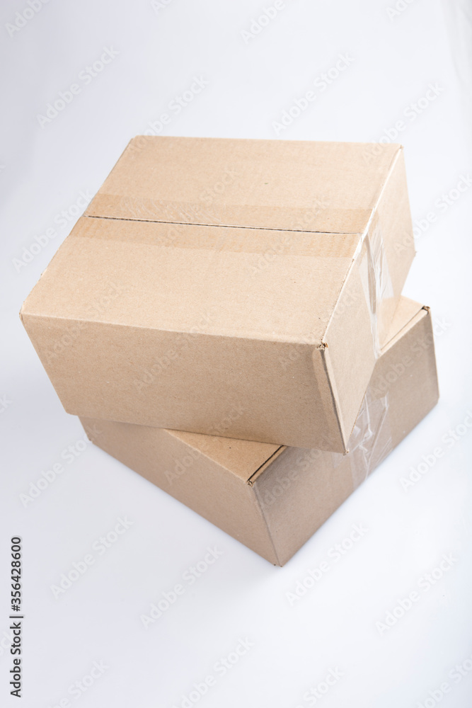isolated close up shot of two stacked closed blank brown carton cardboard boxes on a white background isolated close up shot of two stacked closed blank brown carton cardboard boxes on a white background