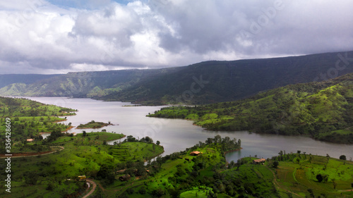 Aerial/Drone View of a river valley and an offbeat holiday resort in green surroundings during Monsoon season in Maharashtra, India.