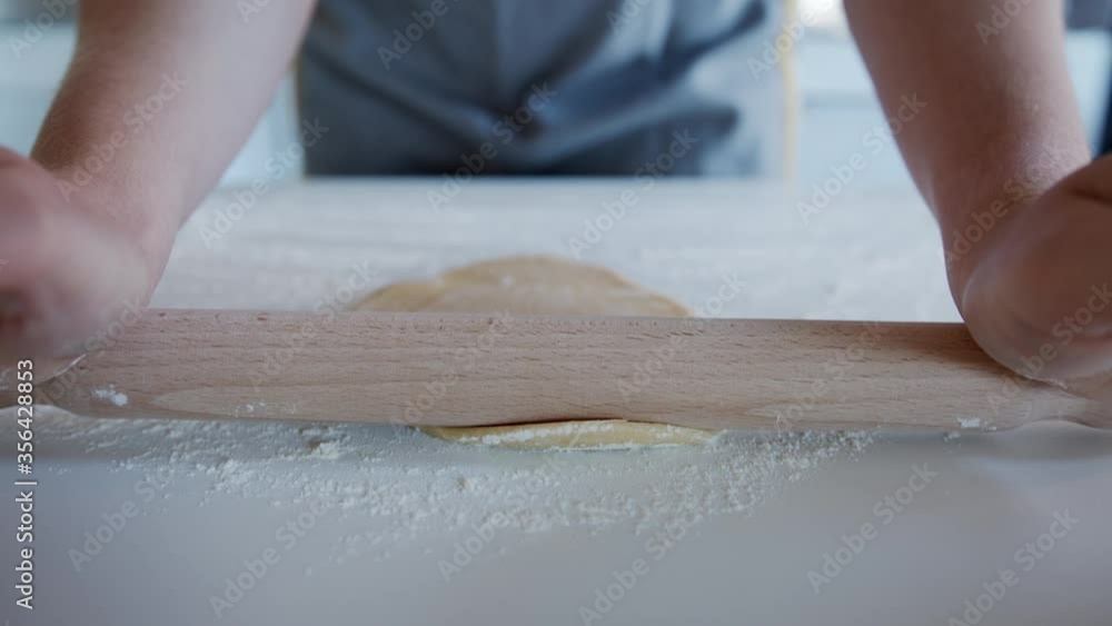 Close up Follow Focus, Anonymous person using a rolling pin to Roll out Dough at Home. Making Pasta. Close up Follow Focus, Anonymous person using a rolling pin to Roll out Dough at Home. Making Pasta.