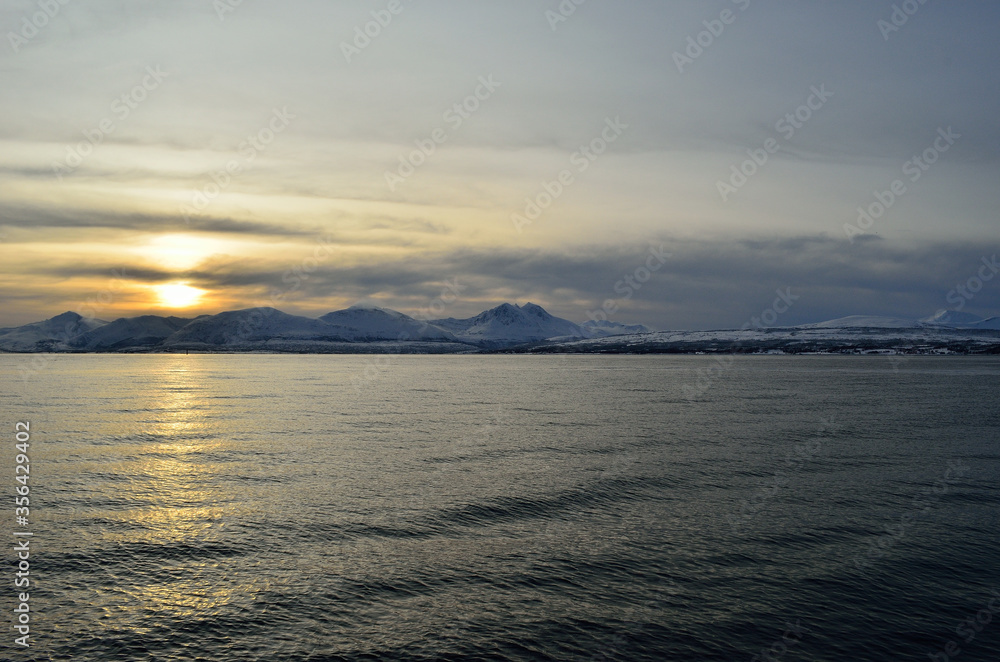 beautiful sunset over snowy mountain and fjord