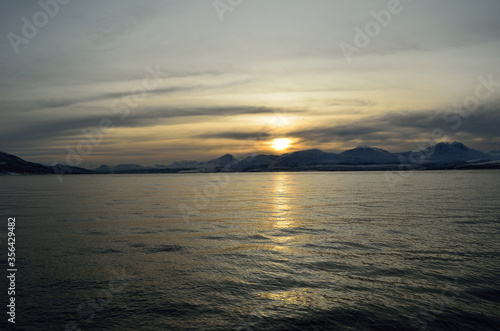 beautiful sunset over snowy mountain and fjord