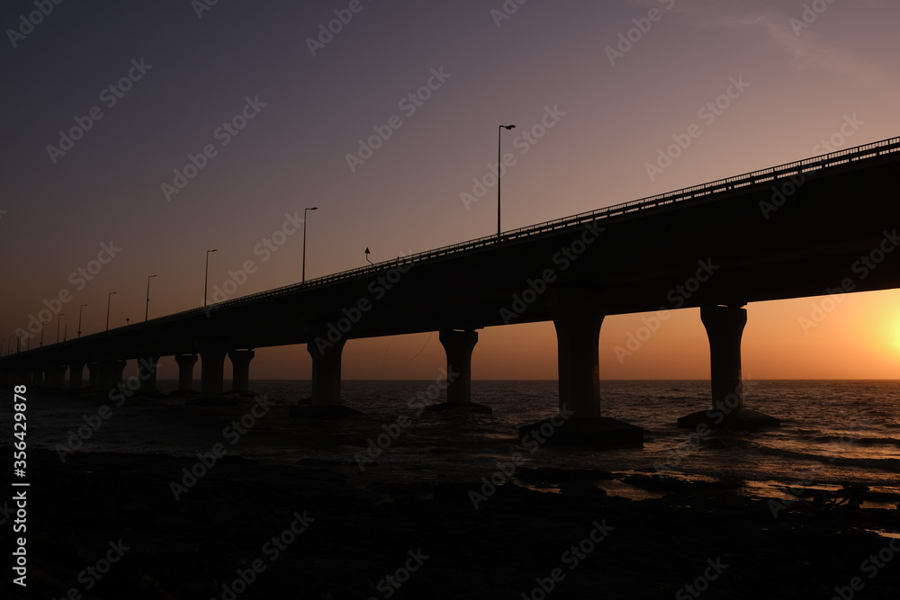 An evening by the beach: Bandra Worli Sea Link, Mumbai during Sunset, Silhouette of the bridge with Sun setting down