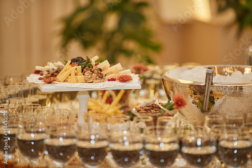 many different snacks and glasses with champagne on a wedding table in a restaurant