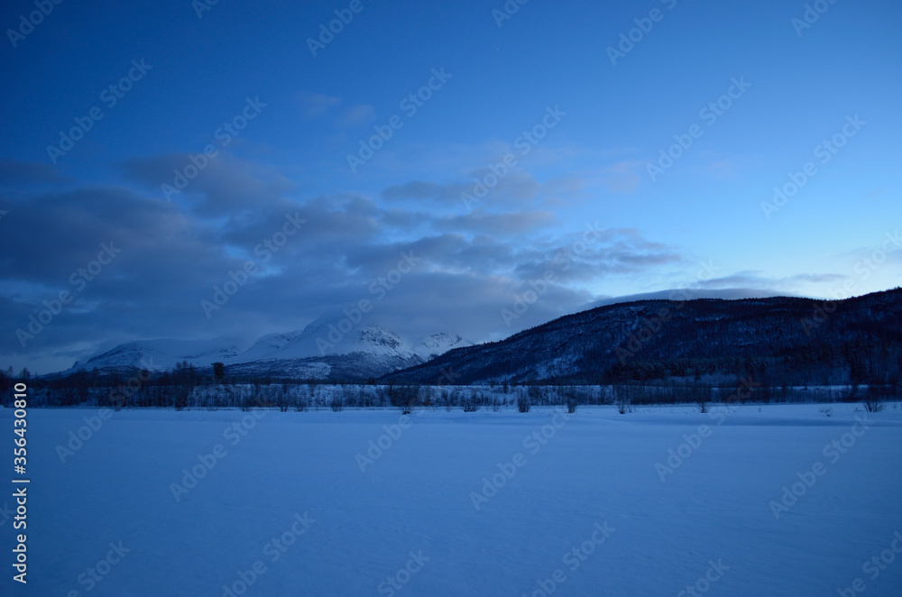 beautiful frozen river and mountain landscape in the high north winter