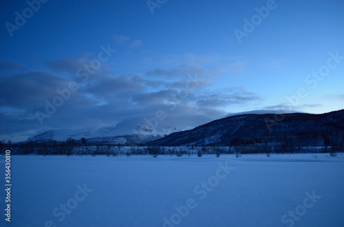beautiful frozen river and mountain landscape in the high north winter