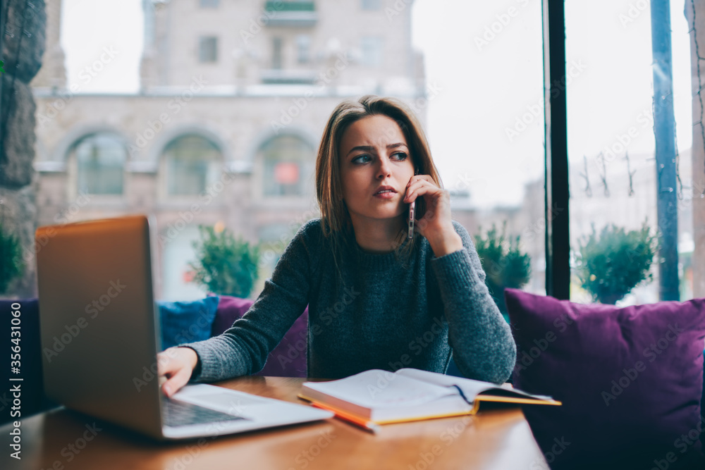 Obraz premium Smiling attractive student spending free time in coffee shop interior on exam preparation