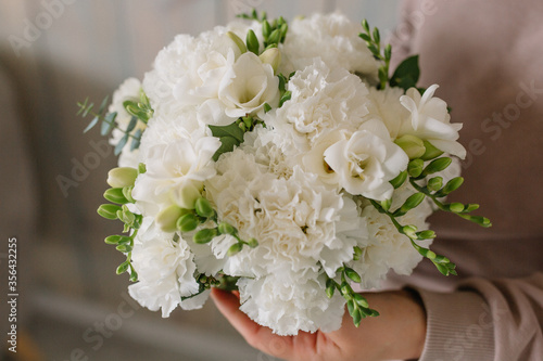 Beautiful girl’s bouquet in the hands of carnations and other flowers