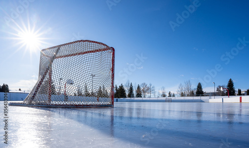 Hockey net on clear sunny winter day with sunburst on fresh ice