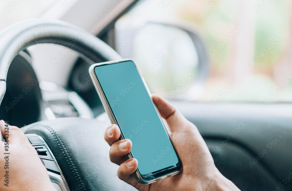 Closeup woman hand playing smartphone mobile with relaxing feelling in the car, selective focus