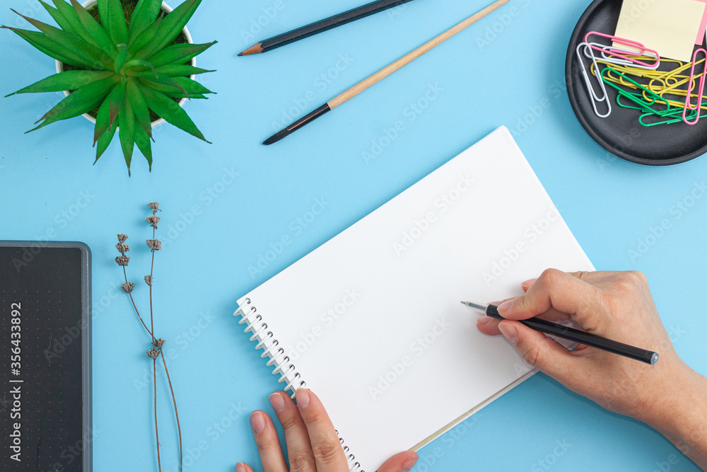 Office desk table with blank notebook, computer, supplies and coffee cup
