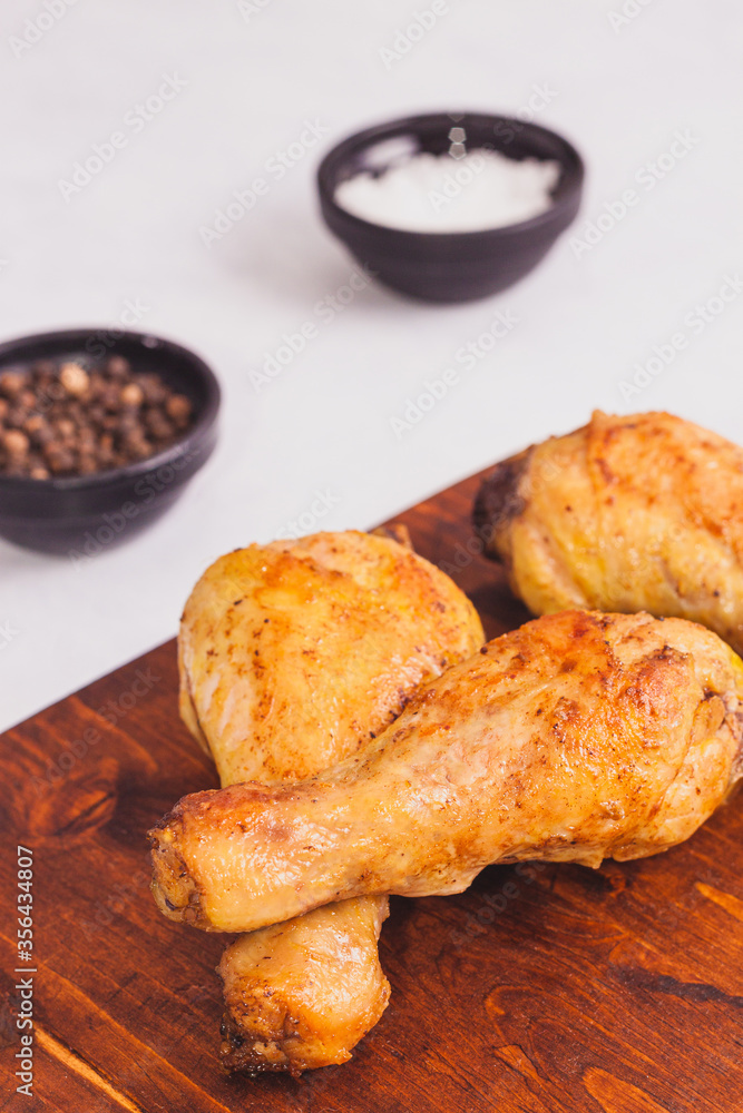 Fried crispy chicken legs, Thigh wooden cutting board with spice on table Fried crispy chicken legs, Thigh wooden cutting board with spice on table