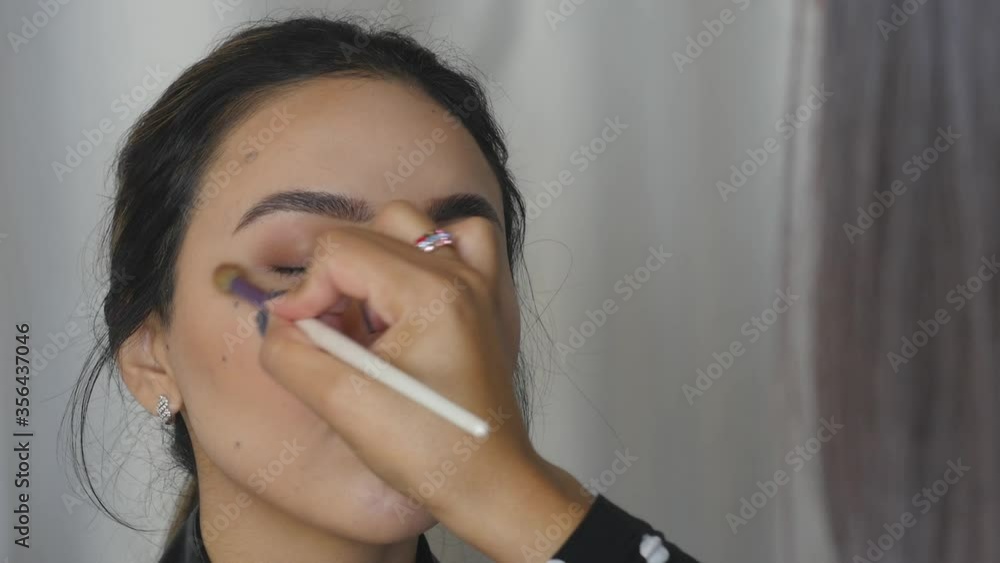 Makeup artist applying eye shadows Makeup artist applying eye shadows