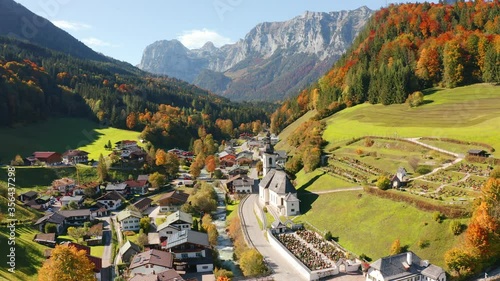 4k drone flight moving to the side footage (Ultra High Definition). Colorful morning scene of Ramsau bei Berchtesgaden village with St. Sebastian Church. Bright autumn view of Bavarian Alps, Germany.